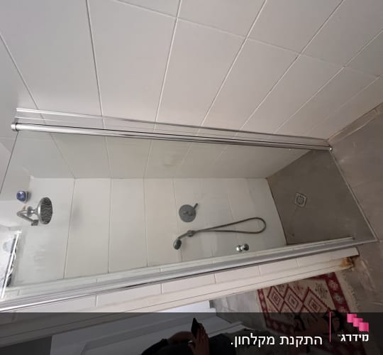 מקלחון זכוכית מותקן בחדר רחצה עם פרופילי אלומיניום